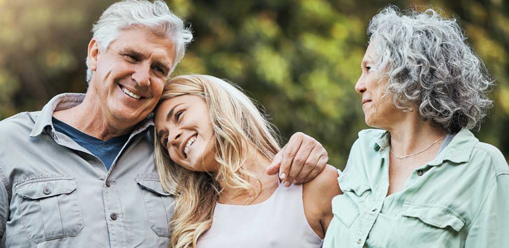 Happy grandparents hugging their grandaughter