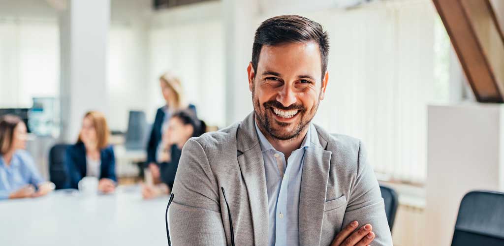 Smiling businessman with crossed arms in a meeting room