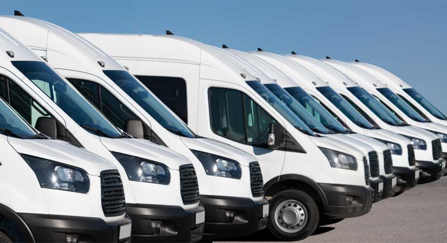White delivery vans are parked in rows