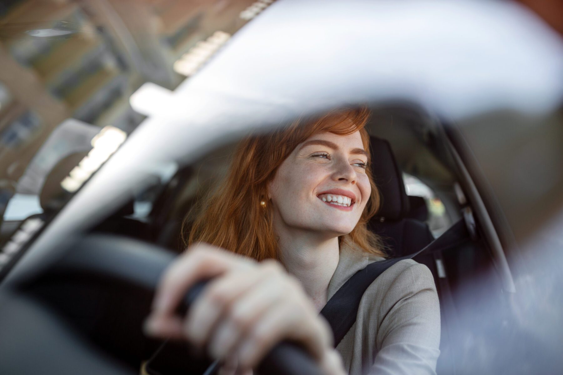 Close up portrait of pleasant looking woman her new car at sunset with a positive expression