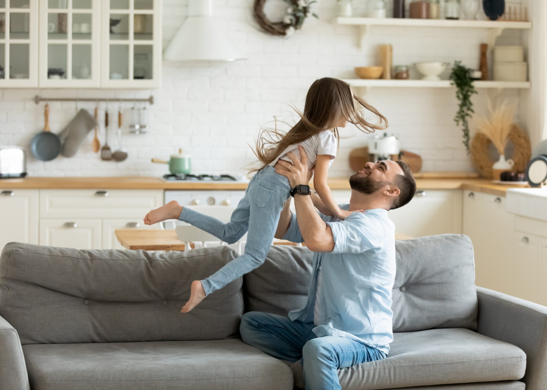 Father and daughter playing on couch happy
