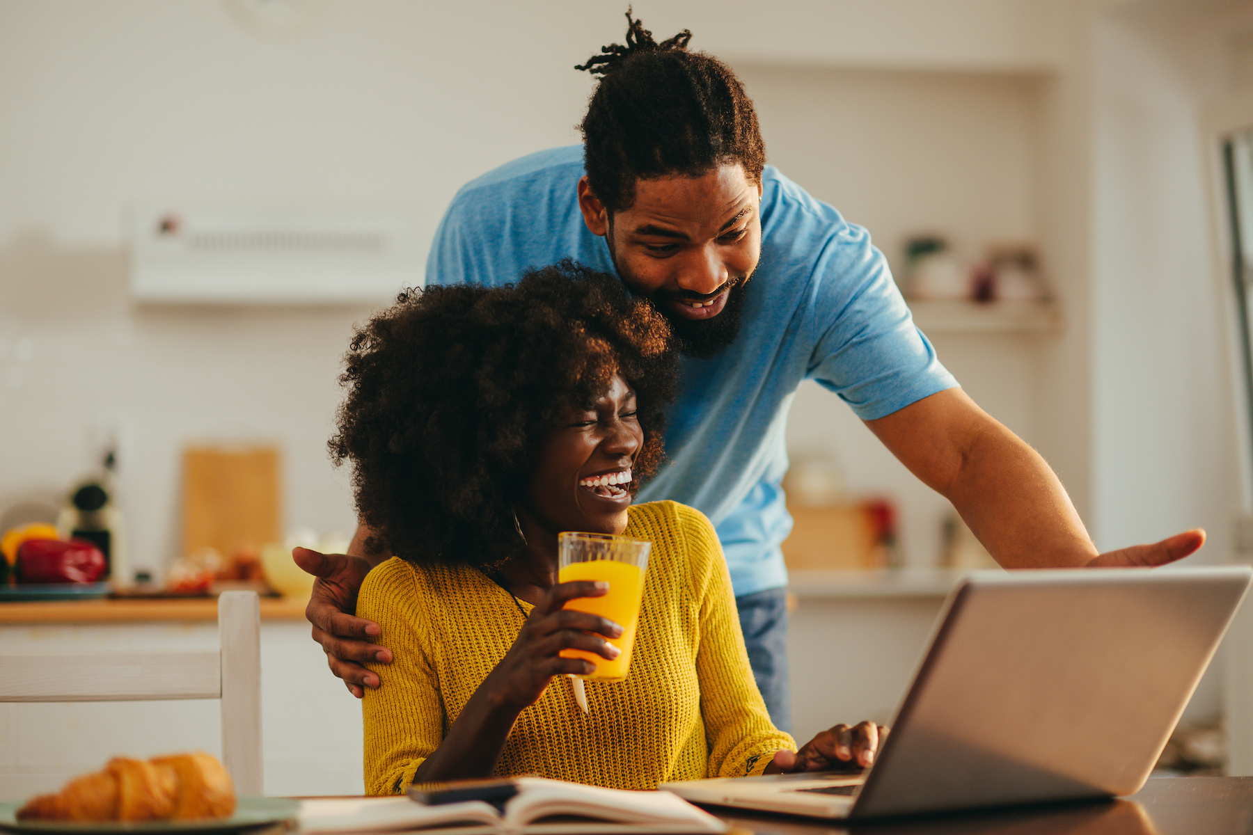 Happy man and woman looking at computer and smiling.