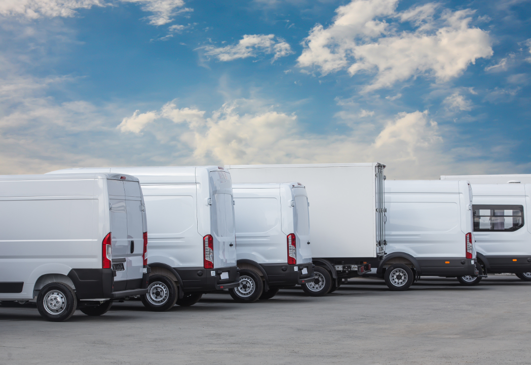 A row of white commercial vans in a parking lot