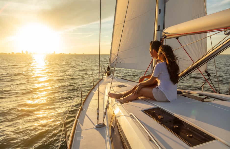 Couple sitting on the deck of a boat looking at sunset