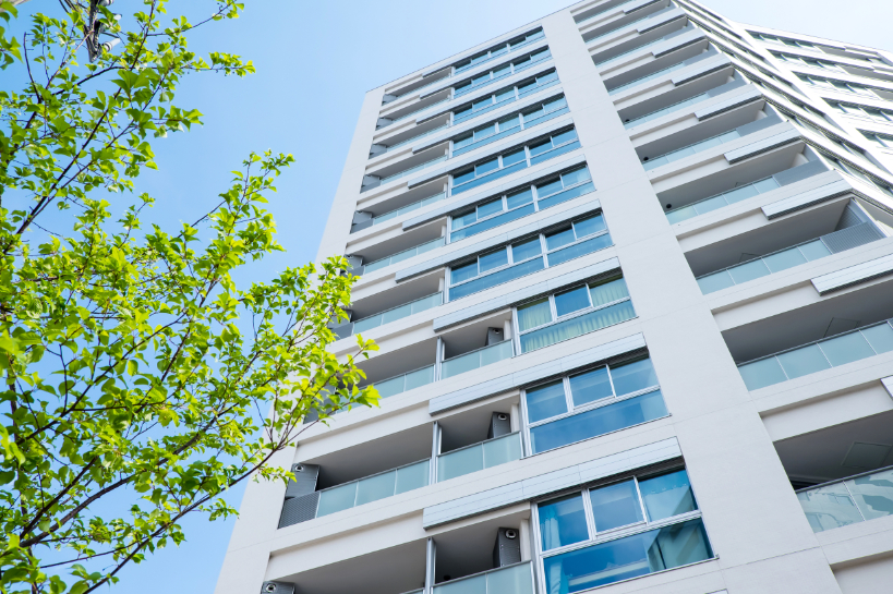 View from street of condo building and three leaves.