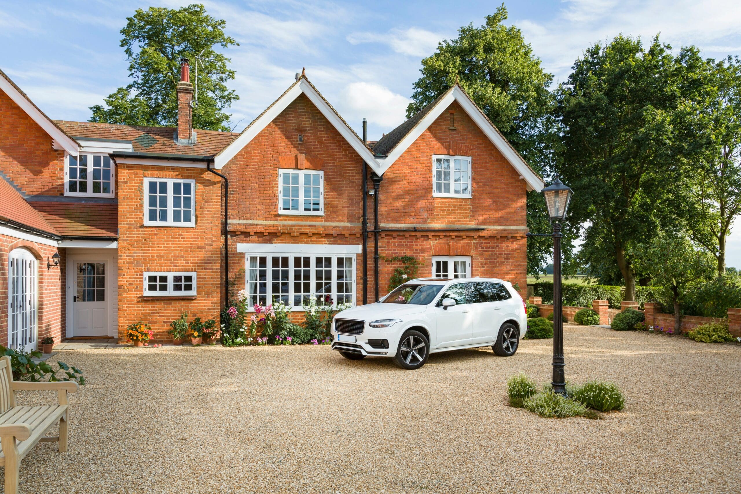 Mansion house and luxury car in a rural setting, 