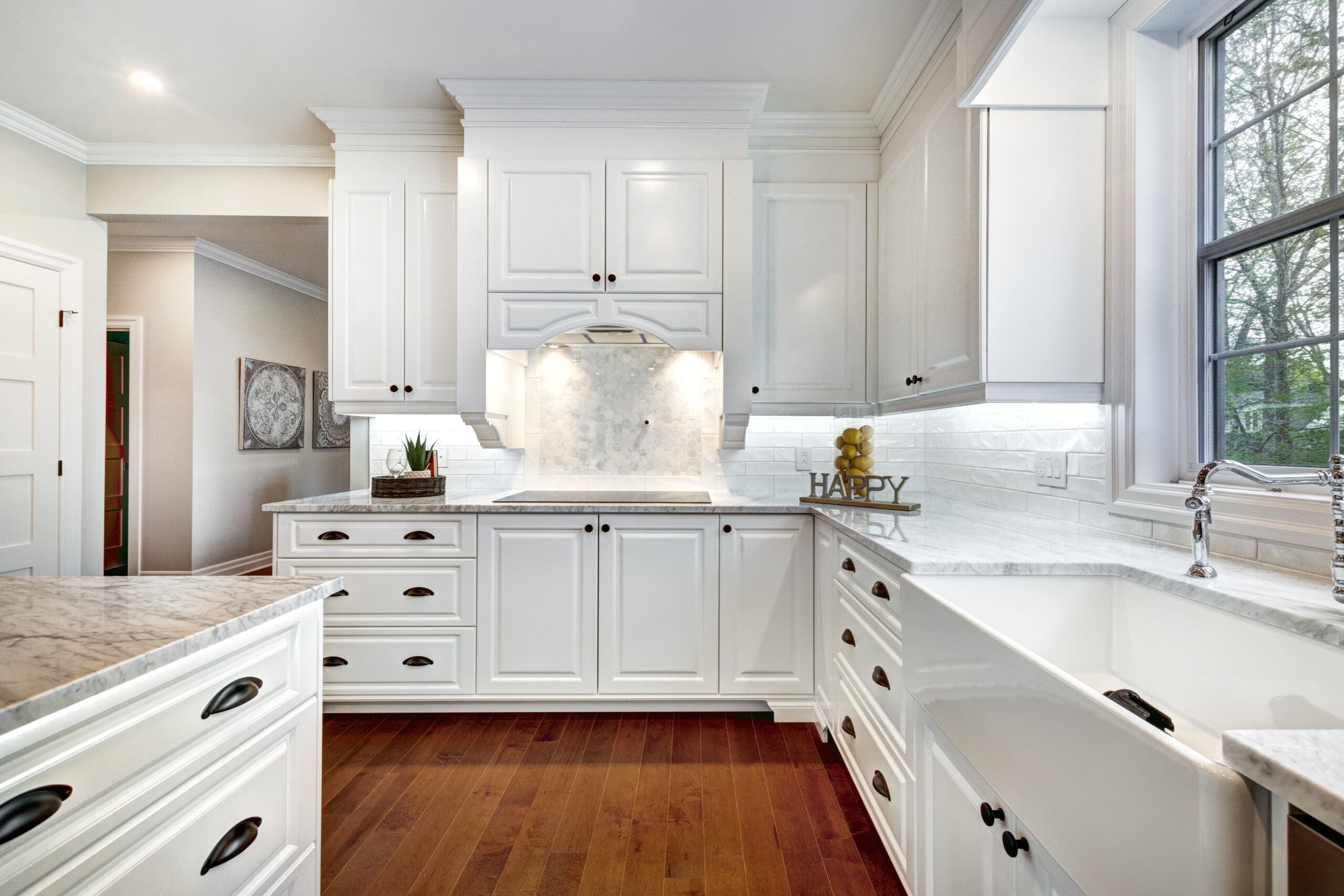 Kitchen with white countertops and white cabinets with wooden floor.