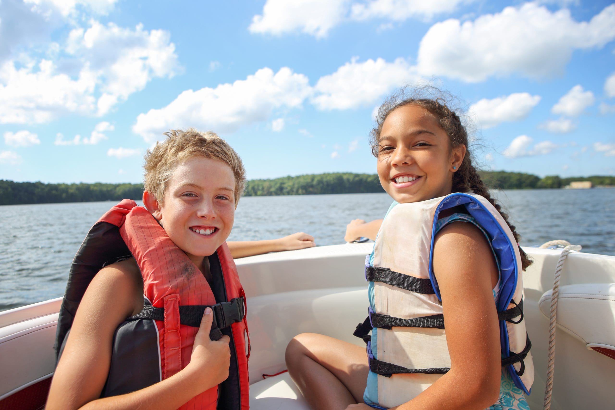 Kids sitting in a boat on the lake.