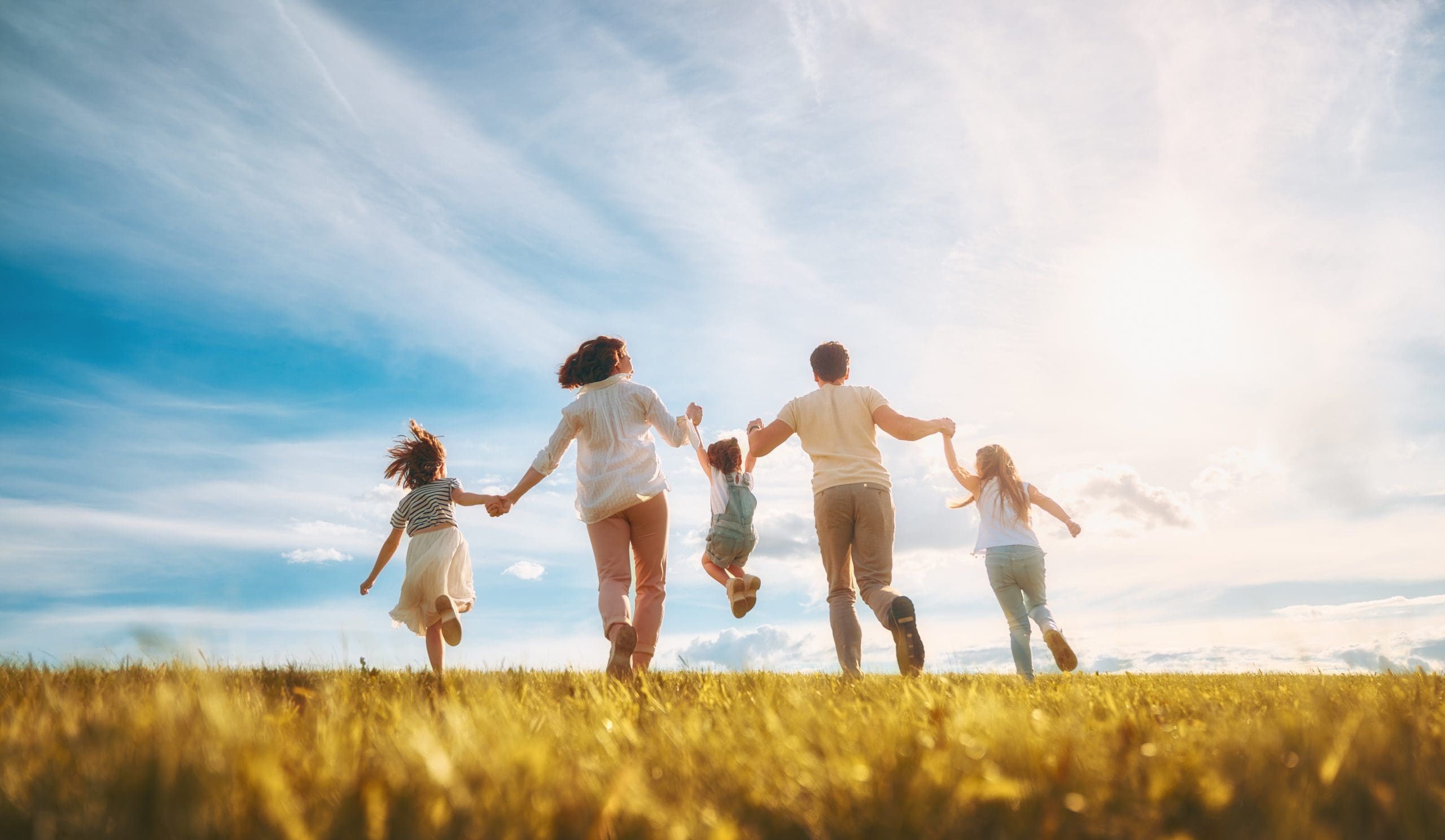 Happy family on summer walk! Mother, father and daughters walking in the Park and enjoying the beautiful nature.