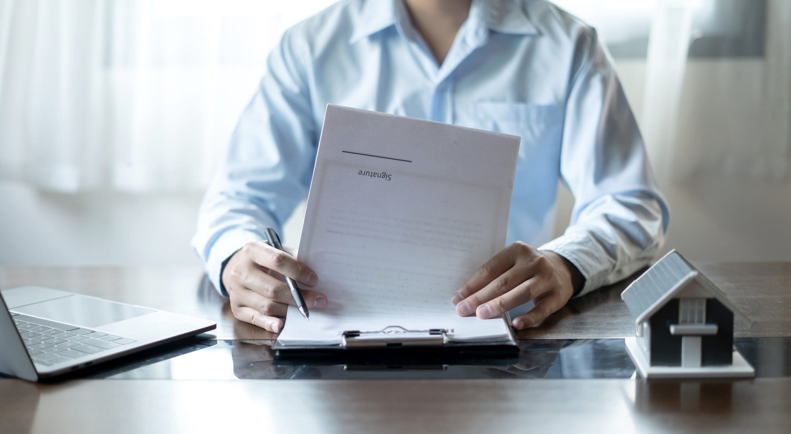 Man holding papers while sitting on table.