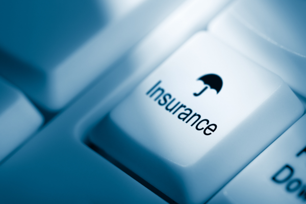 Close up of keyboard with words insurance, and an ambruella.
