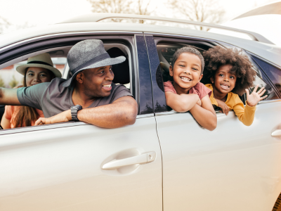 Family smiling inside car.